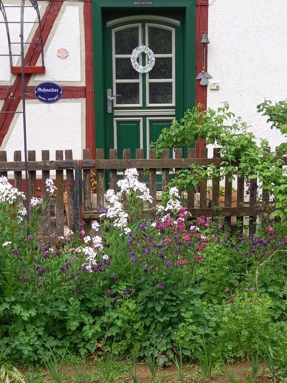 una casa con una porta verde e dei fiori di Kleine Auszeit für nette Leute a Grebenhain