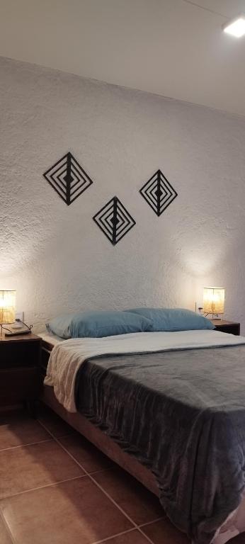 a bedroom with a bed with four crosses on the wall at Terrazas al Sol 03 in Playa Hermosa