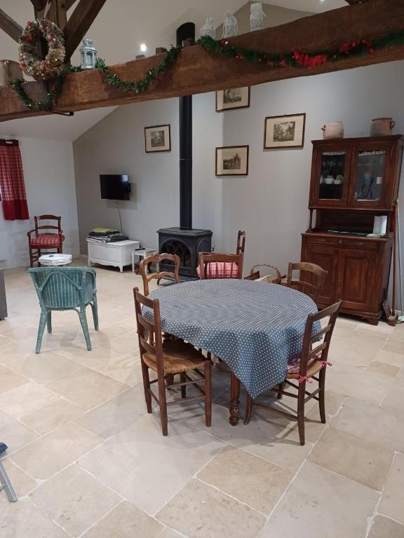 a dining room with a table and chairs and a fireplace at La bergerie de Genouse in Marnay