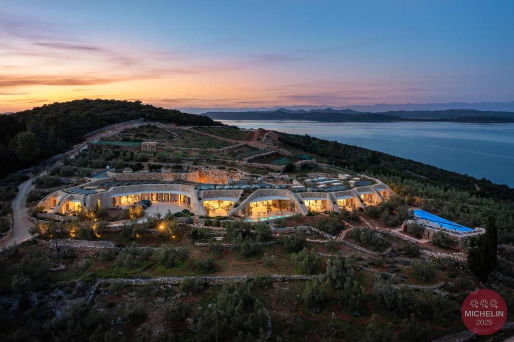 an aerial view of a building on a hill with a lake at Villa Nai 3.3 in Žman