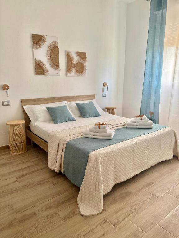 ein Schlafzimmer mit zwei Betten mit blauen Kissen in der Unterkunft Dama House in Porto Torres