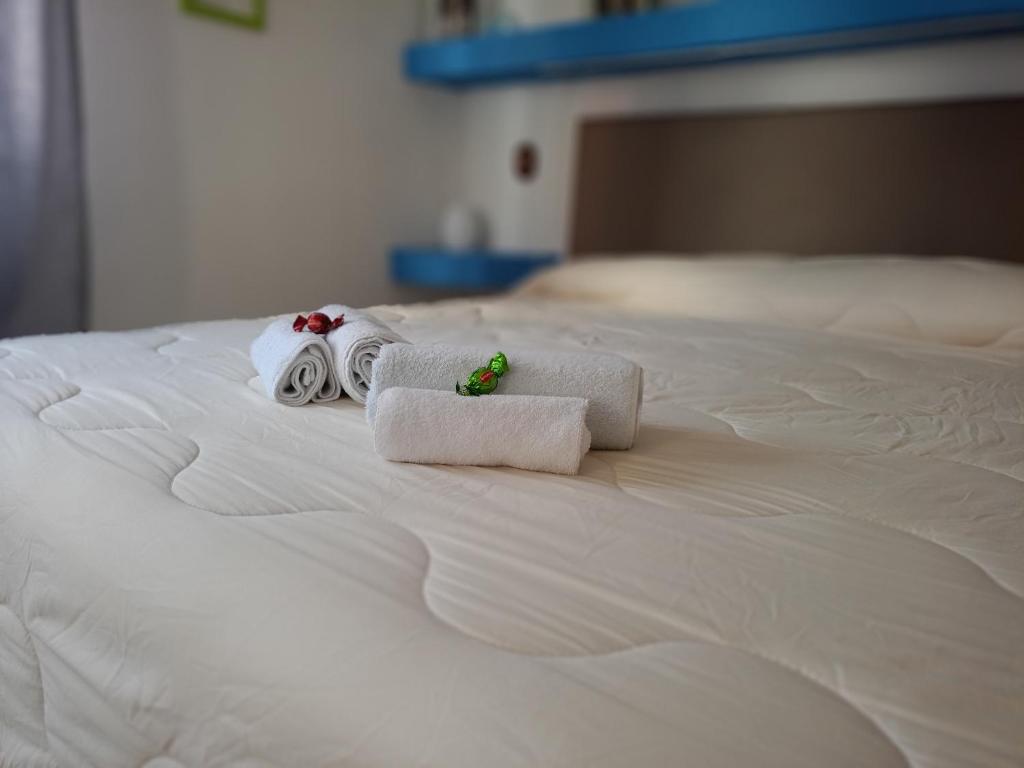 two towels on top of a white bed at KiMia Home, Near Airport & station in Modugno