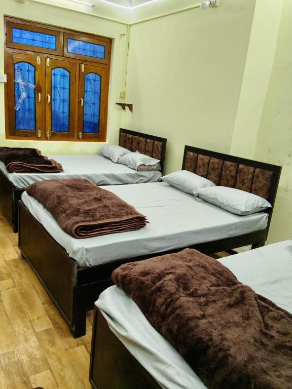 a group of three beds in a room at Tridev Hills in Ujjain