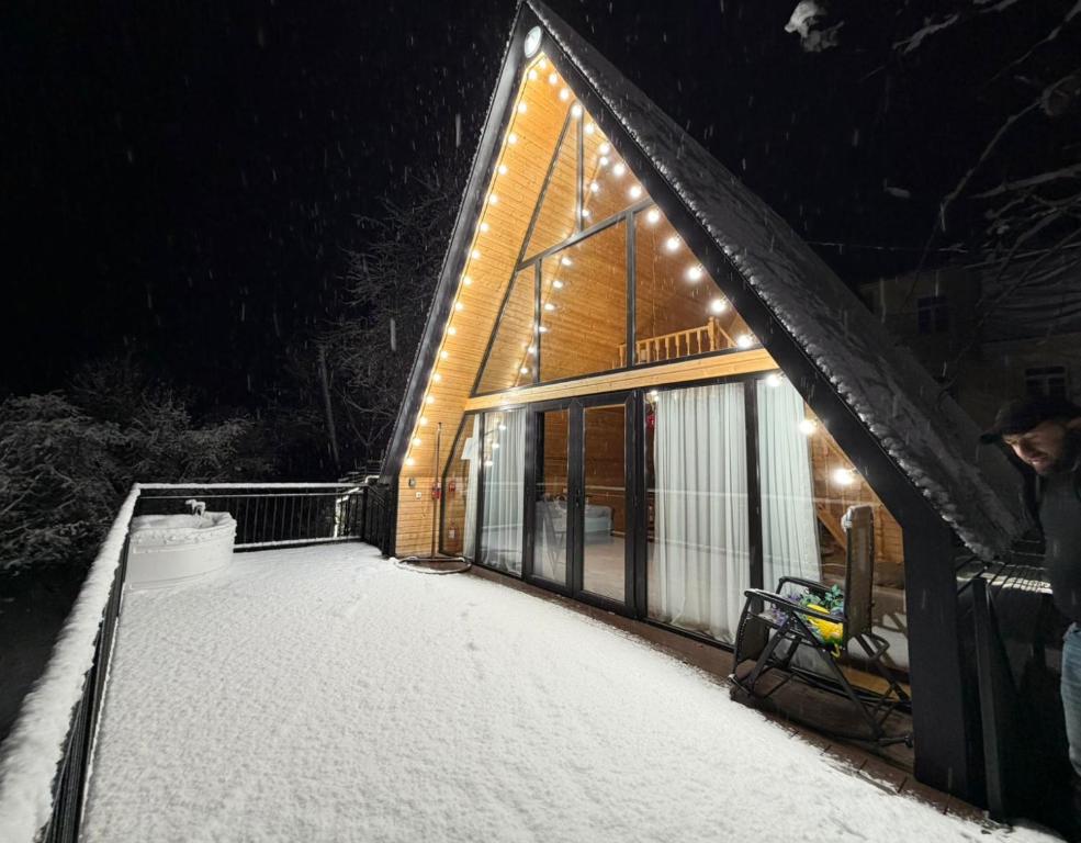 ein schneebedecktes Haus mit Lichtern in der Unterkunft Cottage Mziuri in Tsʼkhemlisi