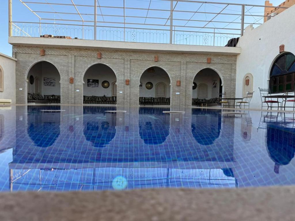 a swimming pool with blue tiles in a building at Camels house apartment in Adrouine