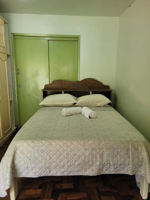 a bedroom with a bed with two towels on it at Quarto privado Brusque Centro ll in Brusque