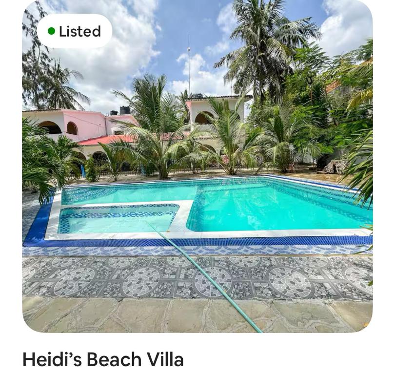 a villa with a swimming pool in a resort at Heidi’s Beach Stay in Mombasa