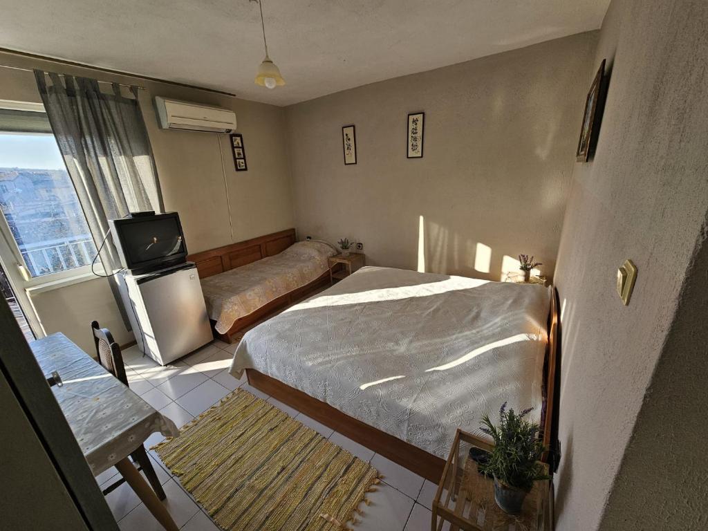 a bedroom with a bed and a tv in it at Villa Lira in Pavel Banya