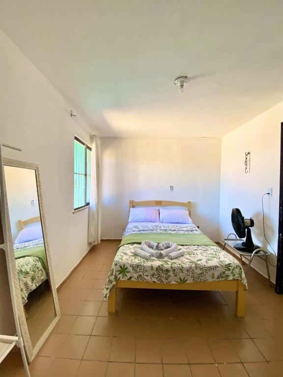 een slaapkamer met een bed en een spiegel bij Green House Cumbuco in Caucaia