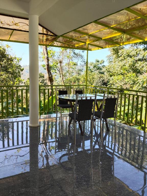 a table and chairs on a balcony with a view at V Land Homestay in Vagamon