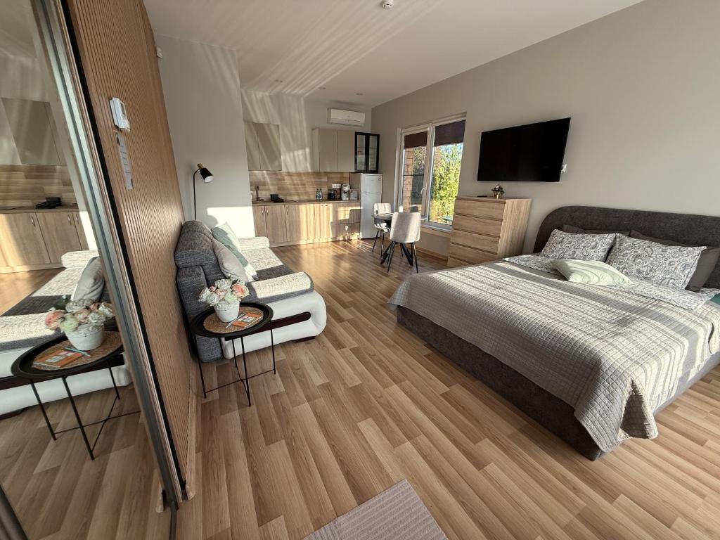 een slaapkamer met een bed en een woonkamer bij Poilsis Kunigiškiuose in Palanga