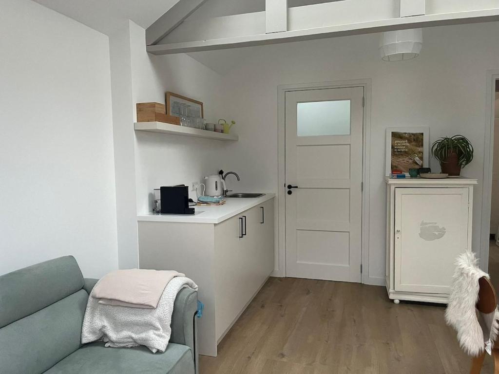 a living room with a couch and a kitchen at Ons Bijhuis in Wijk aan Zee