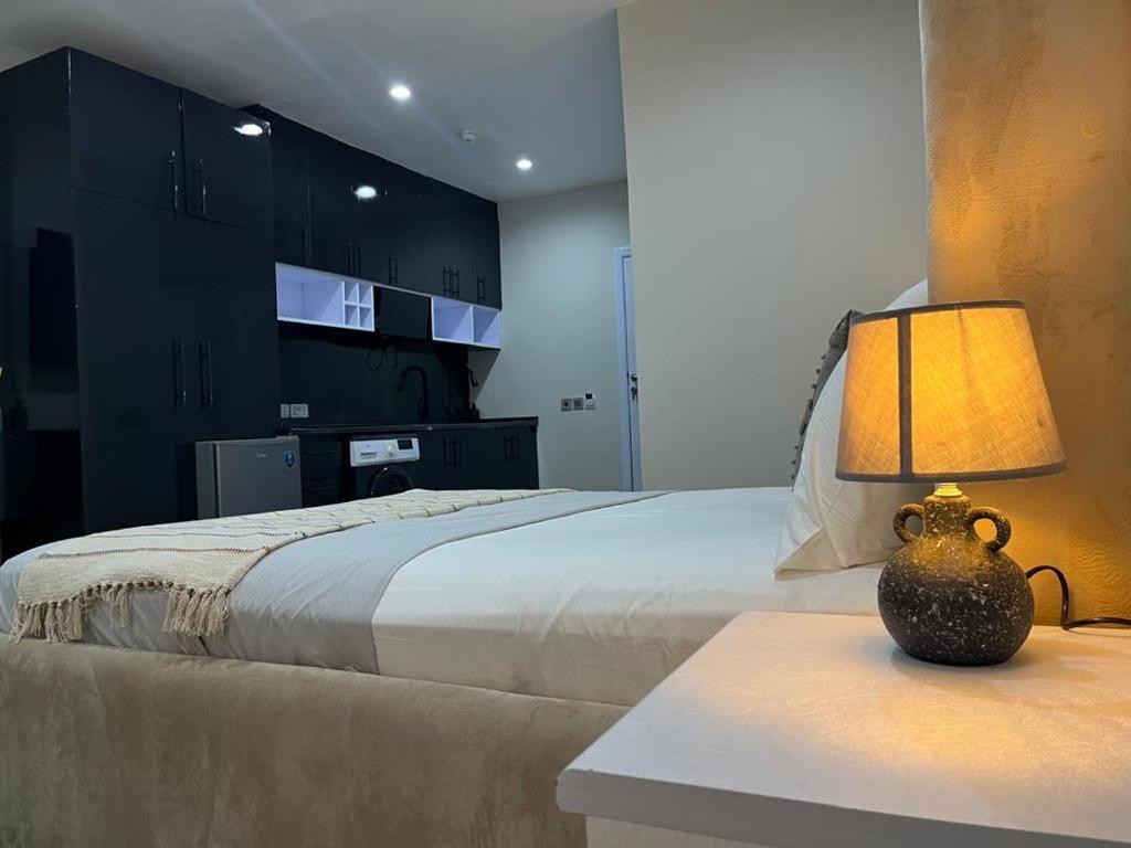 a bedroom with a bed and a lamp on a table at Sylz Residence Studio in Accra