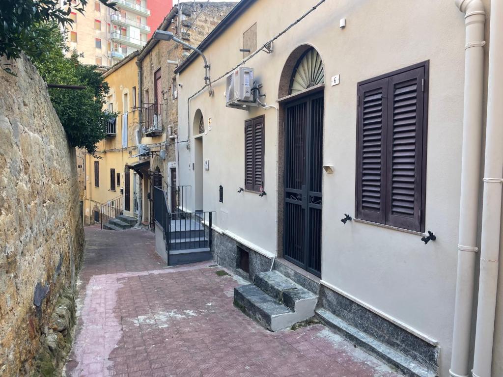 een steeg met een deur en een trap in een gebouw bij Tra Mare e Mito in Agrigento