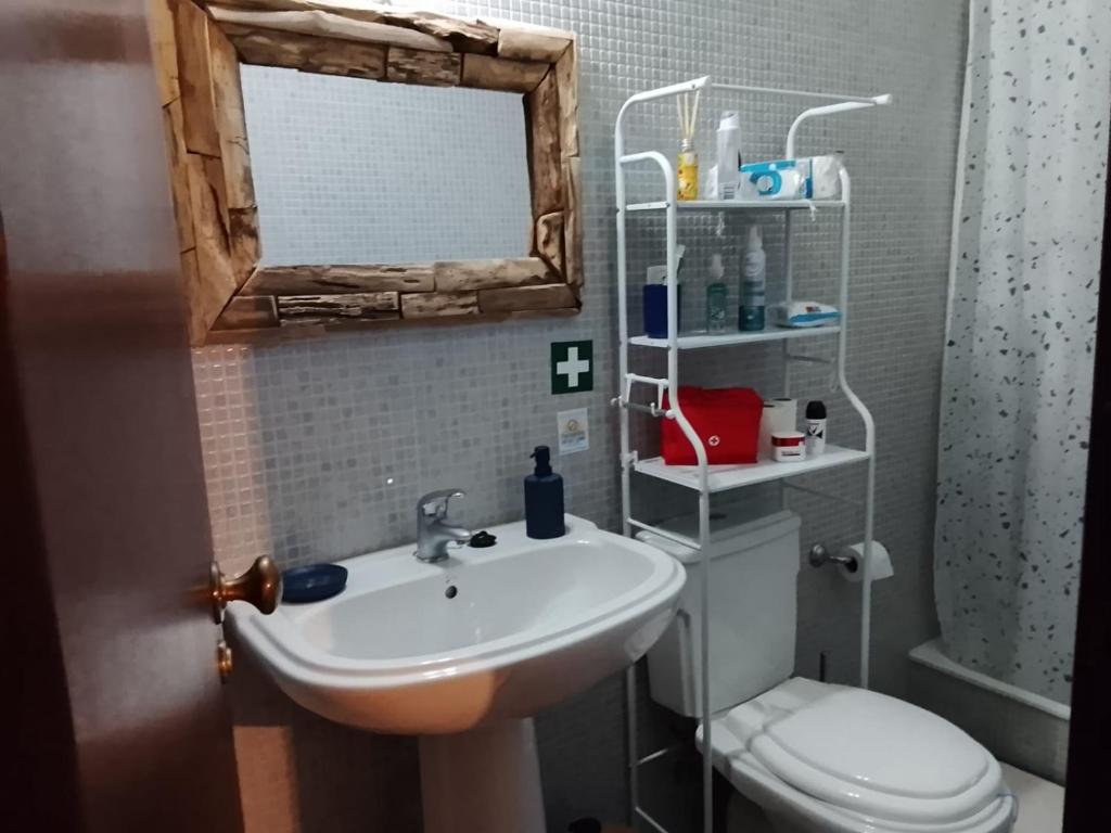 a bathroom with a sink and a toilet and a mirror at Casa Atelier Designer Moda Sandra Silva in Alpalhão
