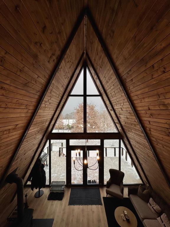 a room with a large window in a attic at Lakewood Cabin - Surduc Lake in Fîrdea