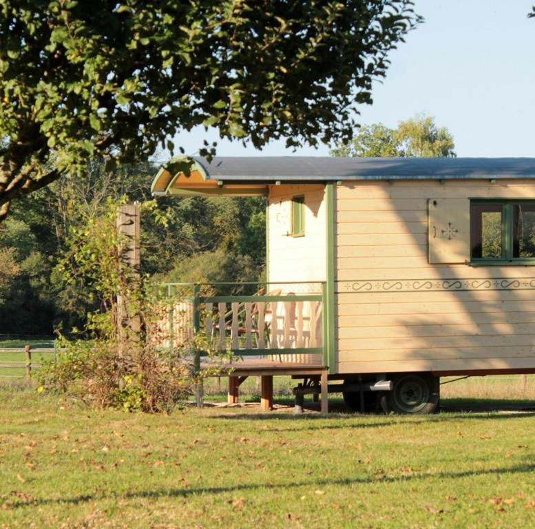 een houten bankje voor een aanhangwagen bij Roulotte & Respire in Foussemagne