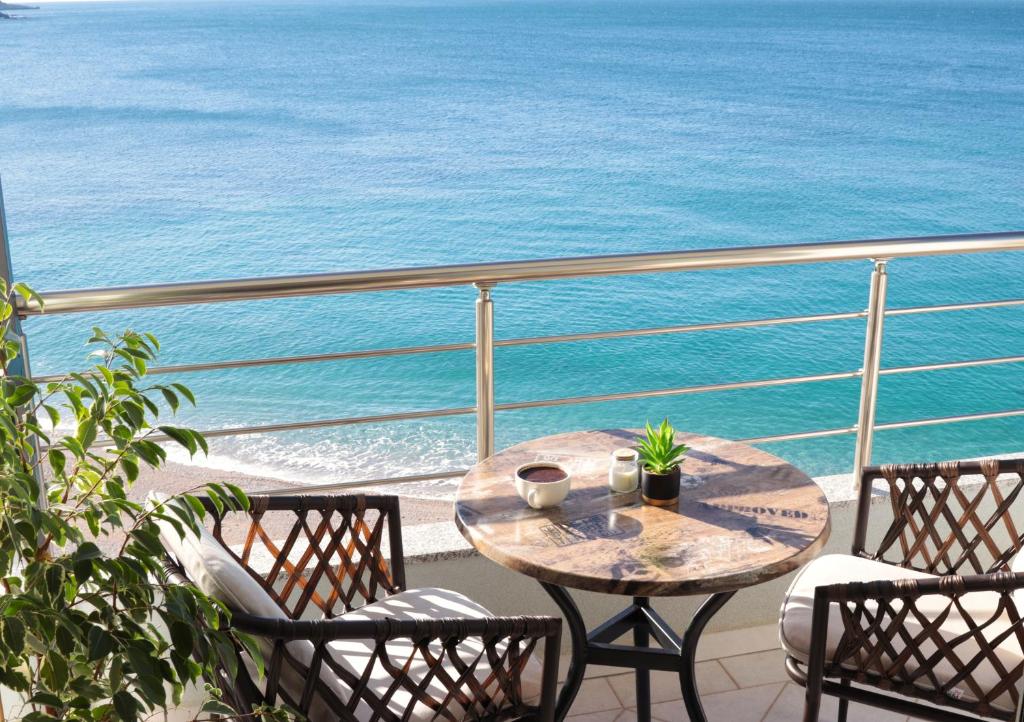 a table and chairs on a balcony with the ocean at Anel Rooms in Himare