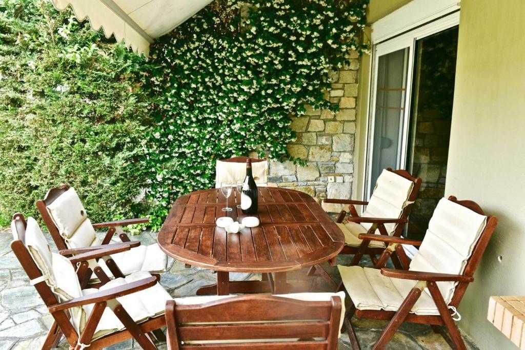 a wooden table and chairs on a patio at Oikos in Hanioti