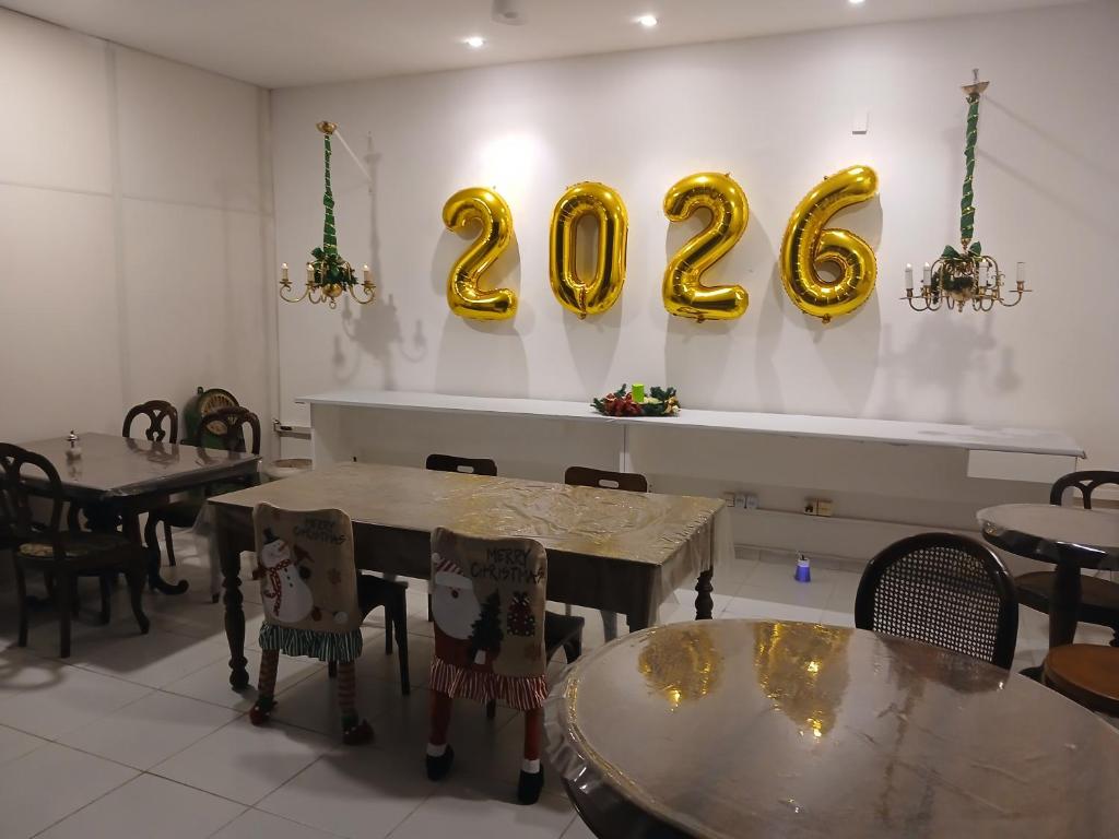 een restaurant met twee tafels en gouden cijfers aan de muur bij Mangue Oranje Hostel - no bairro do Recife Antigo - Old Town in Recife