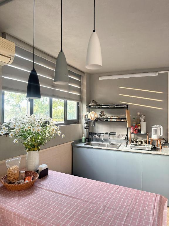 a kitchen with a table with a pink table cloth at Holly House Mộc Châu in Mộc Châu