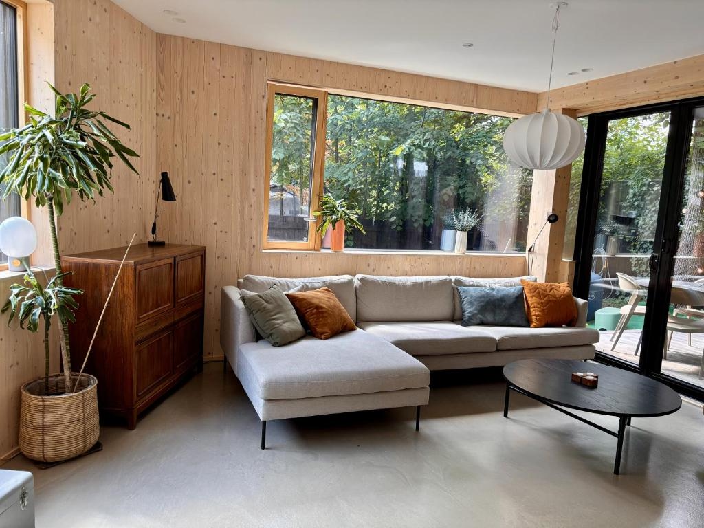 a living room with a couch and a table at The Wooden House, Spacious, garden, new and modern in Oslo
