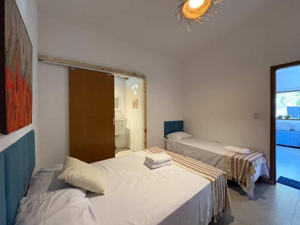 a room with two beds and a window at Pura Vida Hostel e Pousada - Boipeba in Ilha de Boipeba