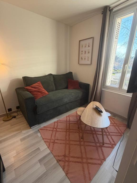 un soggiorno con un divano e un tavolo di Appartement charmant proche Gare a Tours