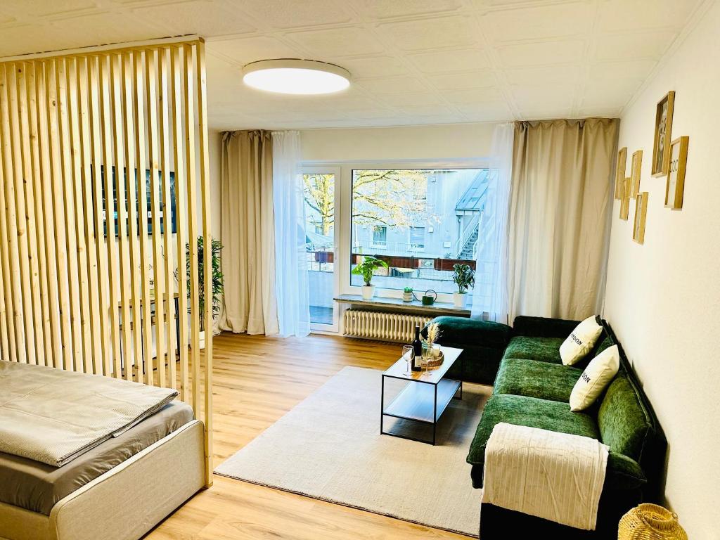a living room with a green couch and a window at MOLA Apartments-Ruhrnahes Apartment mit Balkon & Parkplatz im Herzen von Schwerte-4P in Schwerte