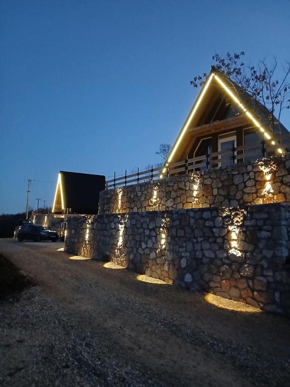 a house with lights on a stone wall at Apartmani Janjusevic in Nikšić
