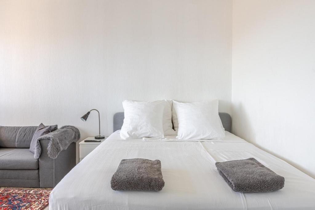 een slaapkamer met een bed met 2 kussens en een bank bij Traumhaftes Studio in Top Lage! in Saint-Louis