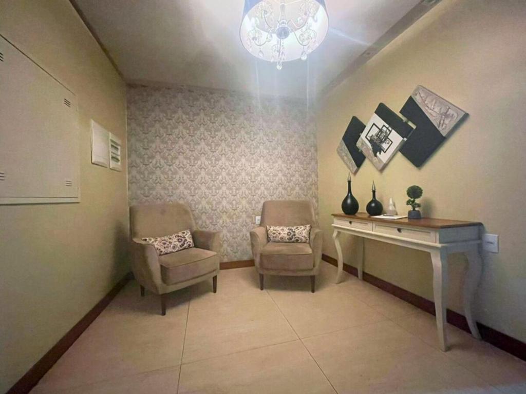 een wachtkamer met een bureau en 2 stoelen bij Apartamento no centro de Torres Rs in Torres