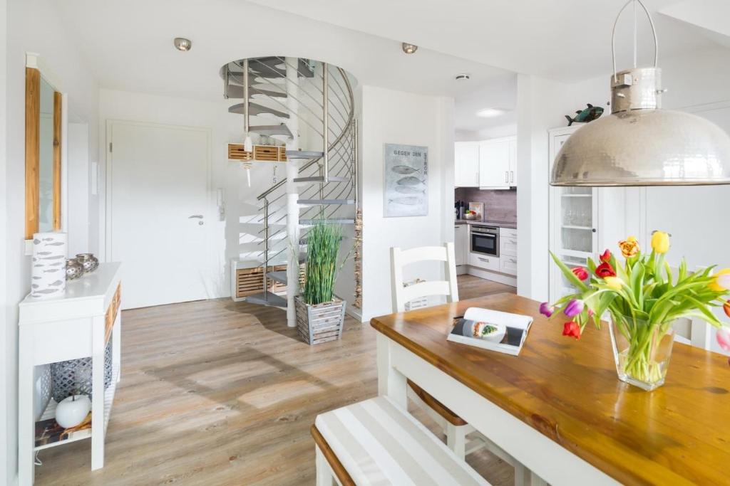 eine Küche mit weißen Wänden und einer hölzernen Arbeitsplatte, die mit Blumen verziert ist in der Unterkunft Strandperle Ney in Norderney