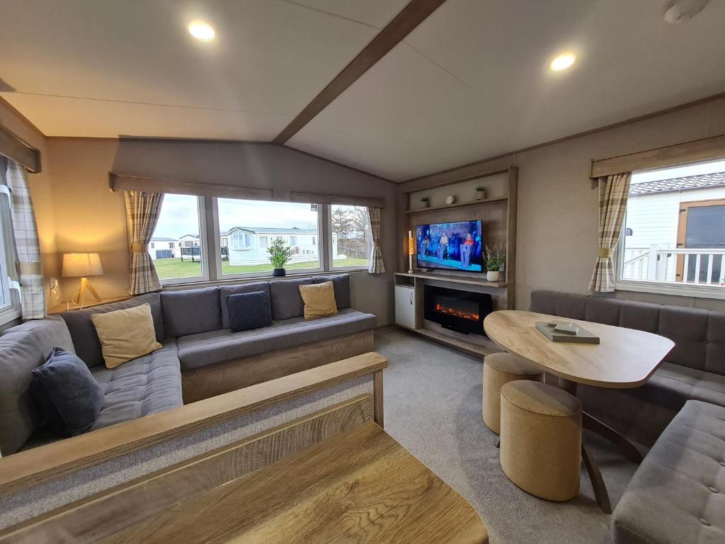 a living room with a couch and a table at Silversands - Private Caravan Let in Lossiemouth