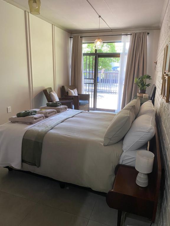 a bedroom with a large bed and a large window at The cozy acre in Potchefstroom