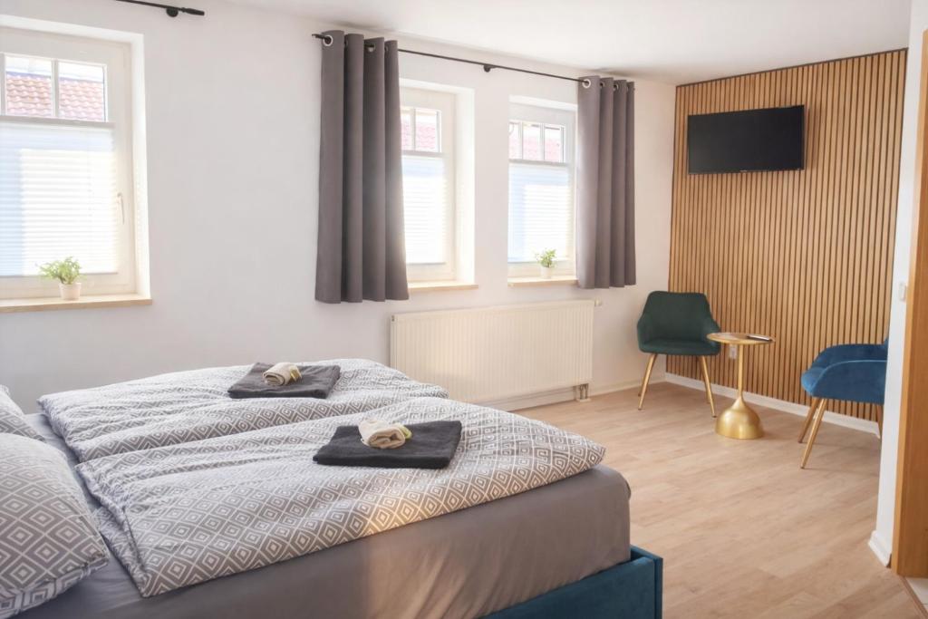 een slaapkamer met een bed met twee handdoeken erop bij Hotel & Restaurant Hasa in Gernrode - Harz