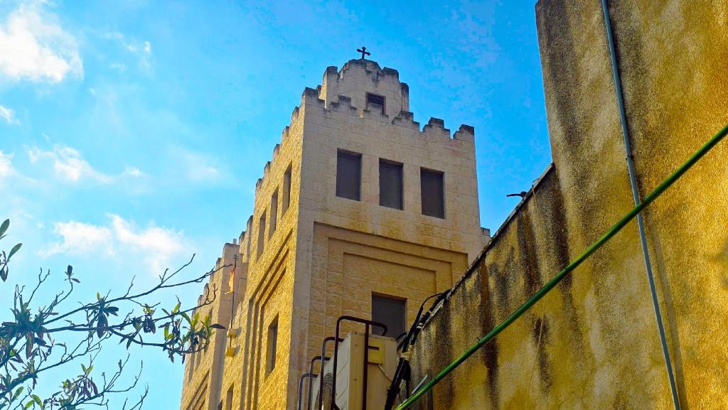 a building with a cross on the top of it at St Thomas Guesthouse - Jerusalem in Jerusalem