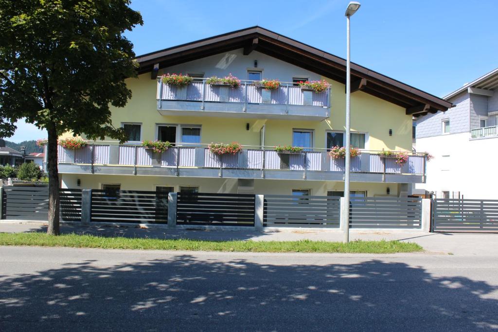 a yellow building with flower boxes on the balconies at Zum Löwen Apartments in Reutte
