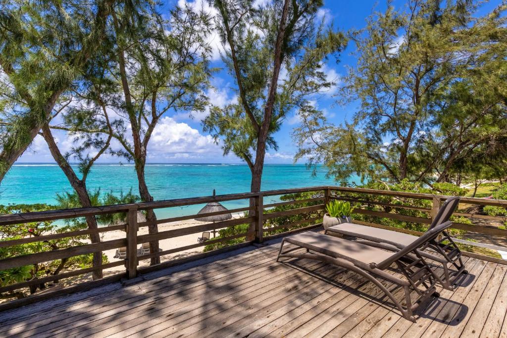 a chaise lounge on a deck overlooking the ocean at BlueMoon Villa - Authentic, seaside living in Trou dʼ Eau Douce