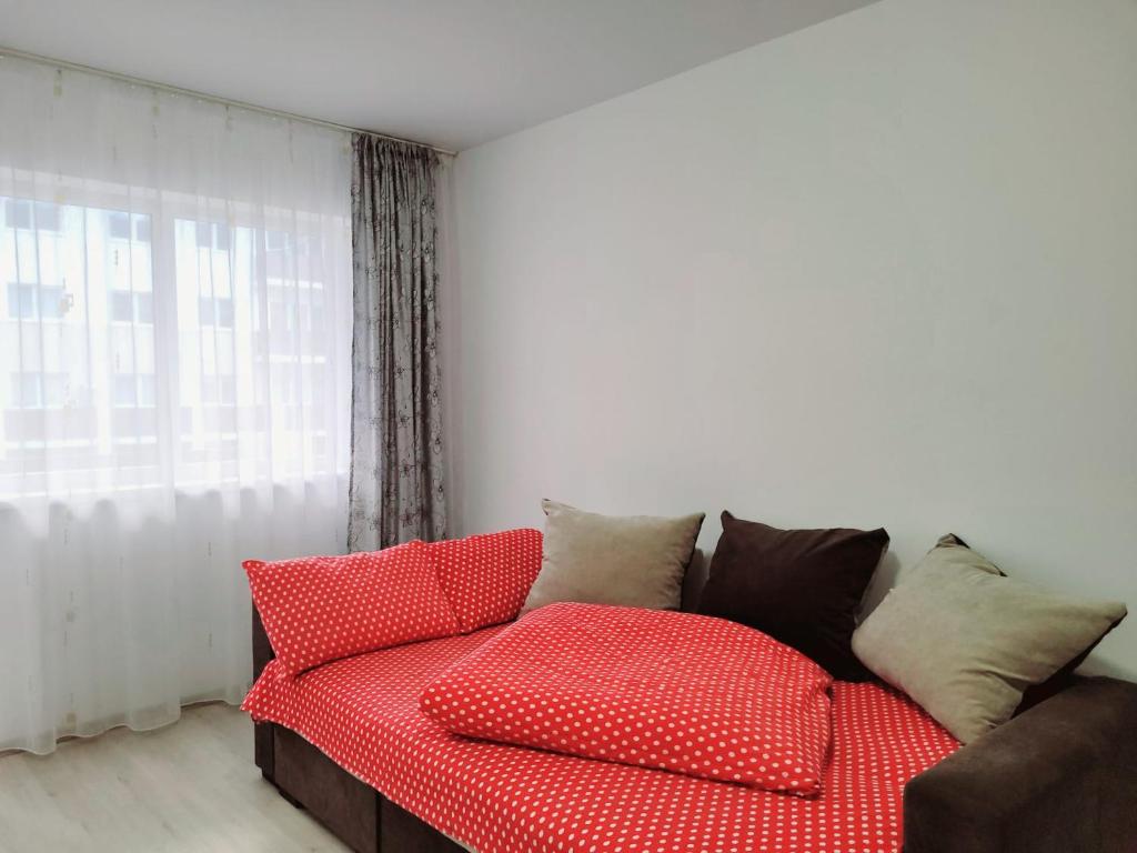 a red couch in a living room with a window at Double rooms apartament in Sînpetru