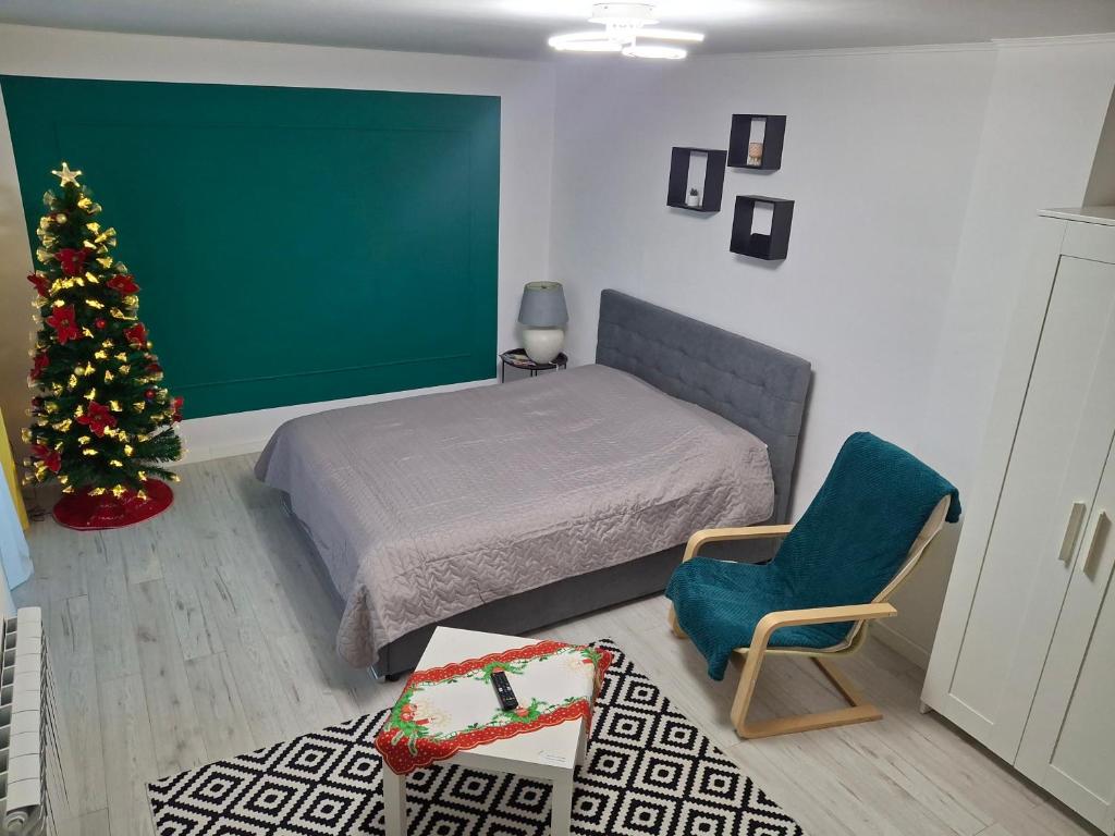 una camera da letto con un albero di Natale e un letto e una sedia di Studio F13 a Topliţa