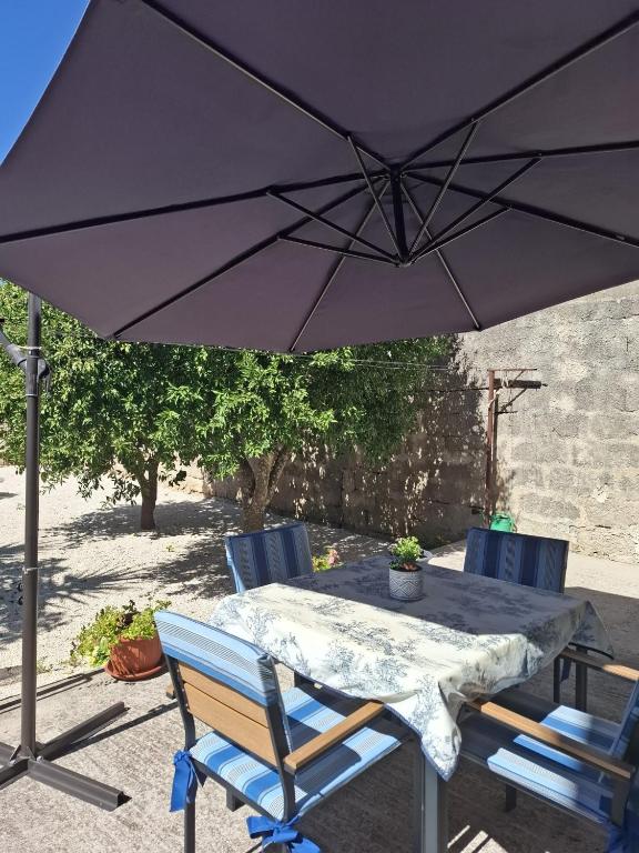 a table with two chairs and an umbrella at Casa Teresina in Cannole