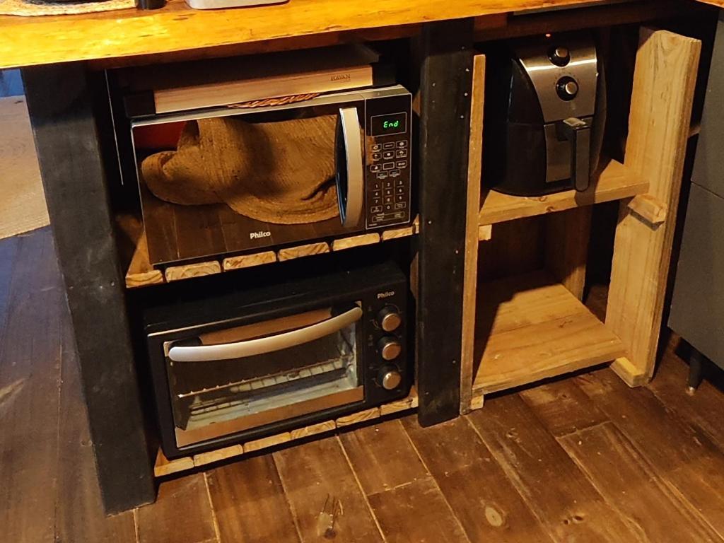 een magnetron op een aanrecht bij Chalé Riacho - Cabana em Contenda - Chalé romântico com hidromassagem in Contenda
