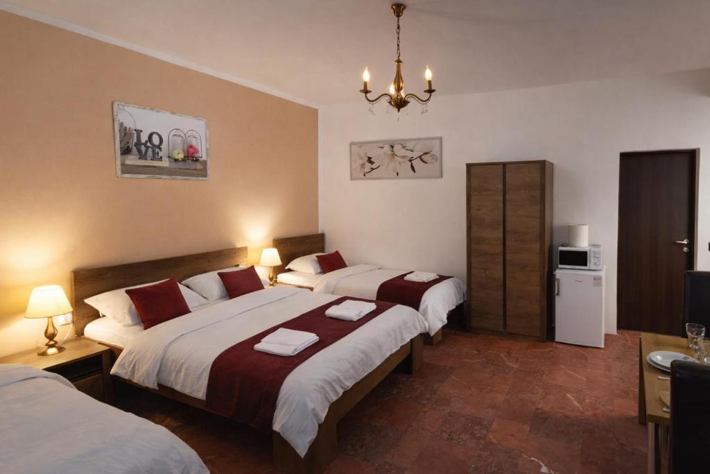 a bedroom with two beds and a chandelier at Ambient Thermal Apartman Gyula in Gyula