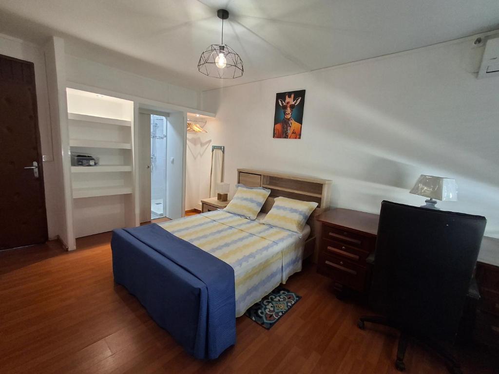 una camera da letto con un letto, una scrivania e una televisione di Osvalley Résidence a Basse-Terre