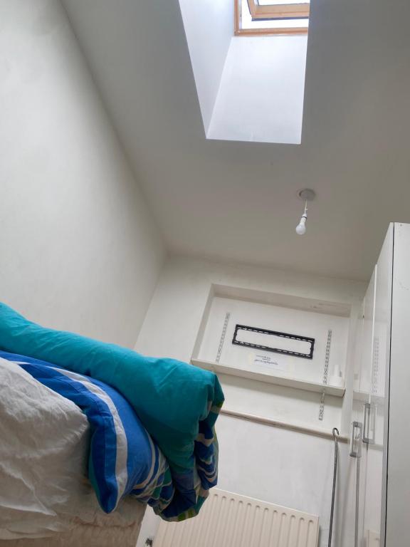 a room with a bed and a window and a vent at Motel in Wednesbury