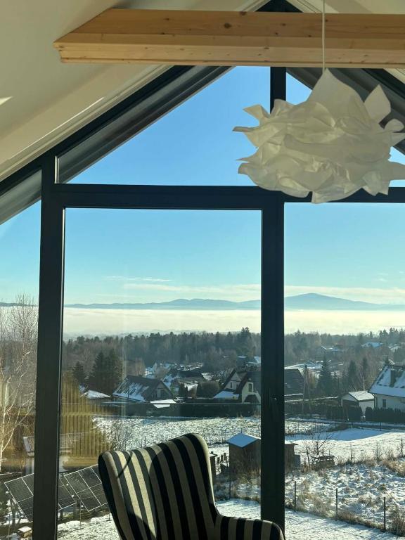 a window with a view of a snow covered city at BeskidView Meszna 1 in Meszna