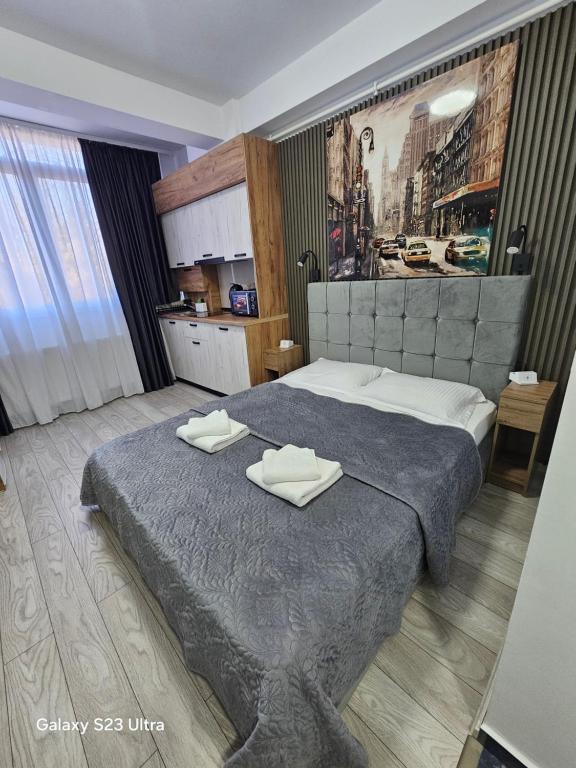 a bedroom with a large bed with two towels on it at AchiDav 135 in Onești