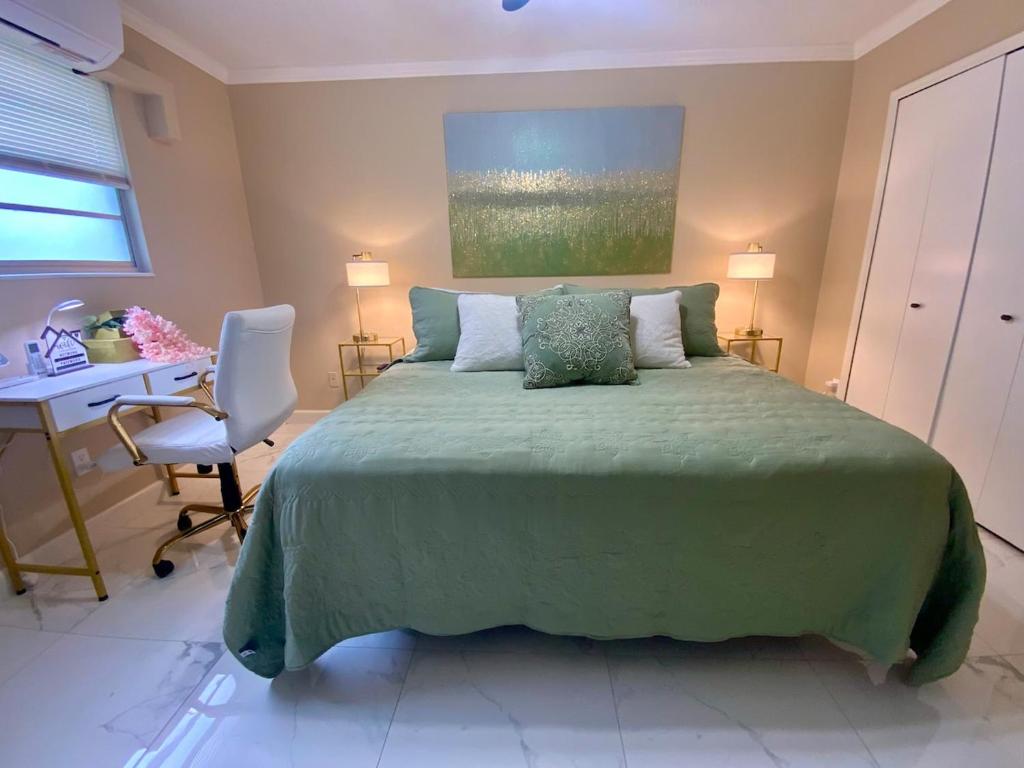 a bedroom with a green bed and a desk at Beautiful Days in Orange Park