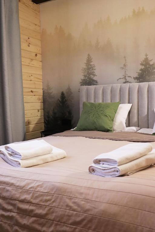 a bedroom with a bed with two towels on it at Садиба "Hutsulyana" in Yablunytsya